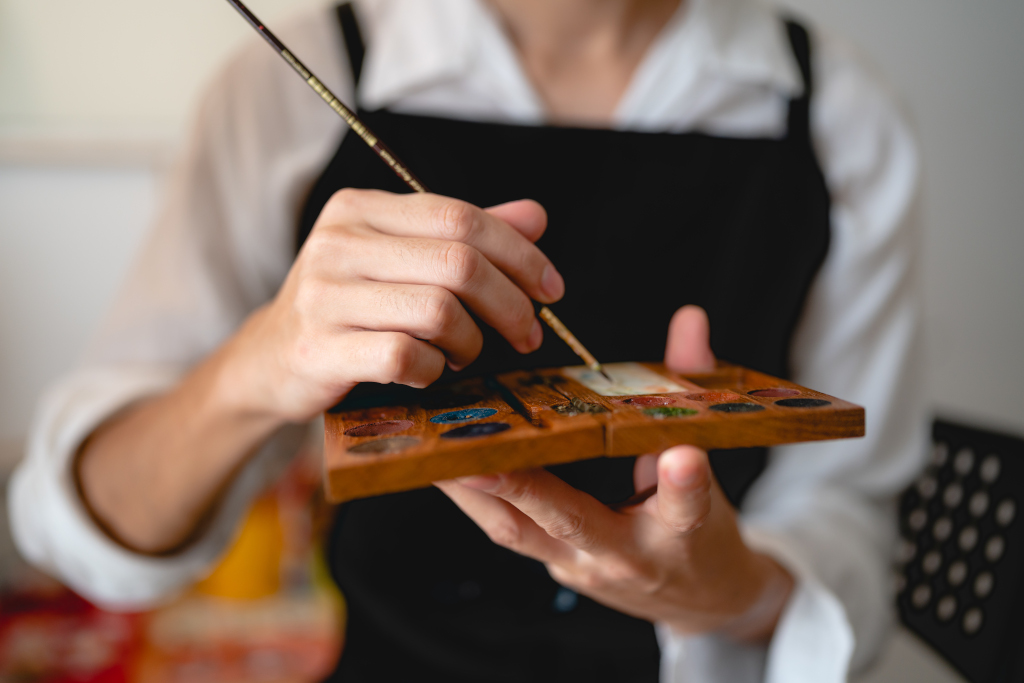 Artiste peintre qui prend de la peinture avec son pinceau