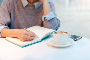 Jeune femme qui écrit dans son journal intime.