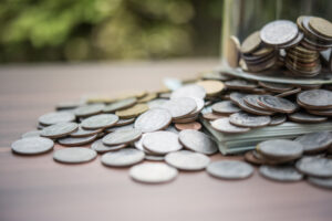 Pièces de monnaie et billets déversés sur une table.