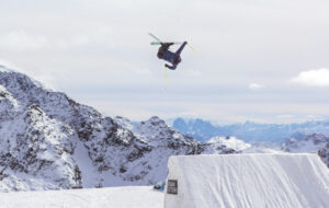 Skieur freestyle qui fait une figure en l'air après avoir sauté une bosse.