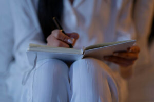 Femme assise qui écrit dans un journal intime.