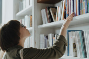 Femme aux cheveux courts qui lit des titres de livres dans une librairie.